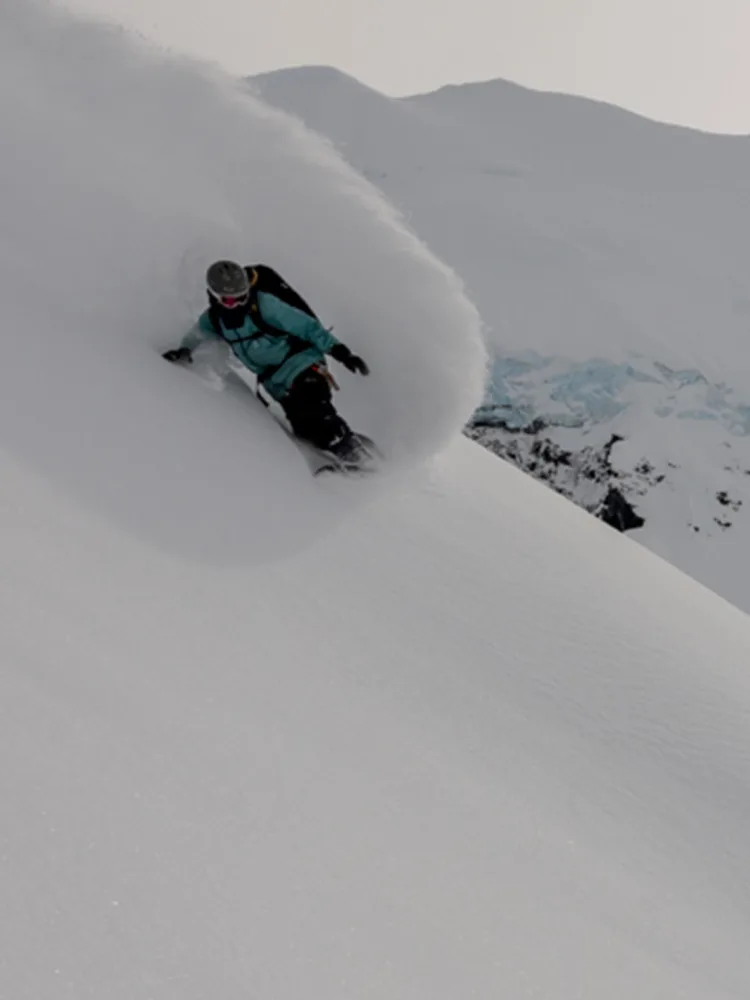 Tailer Gray Spinney snowboarding down a mountain