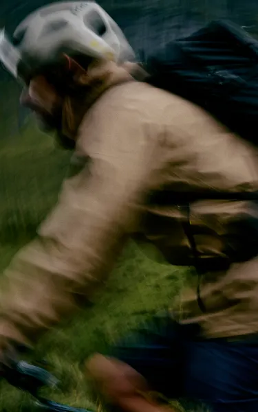 Man cykling on a bike with a beige L.I.M jacket