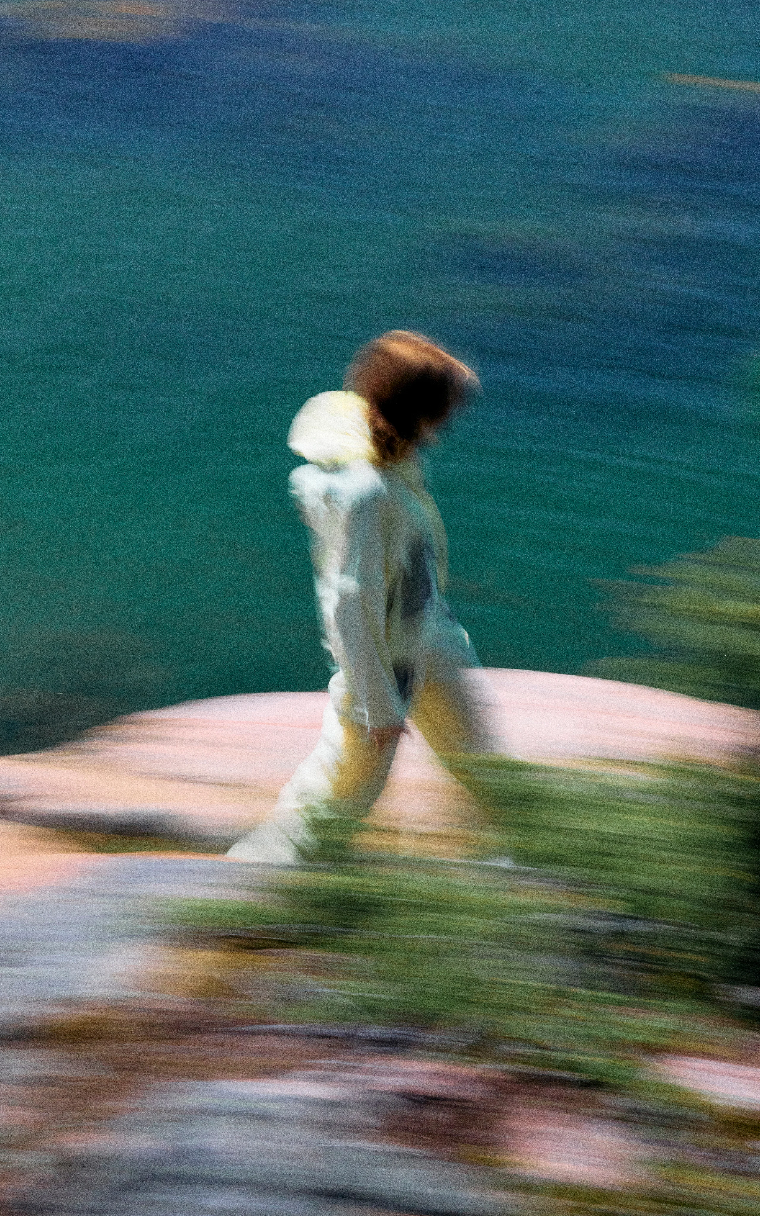 Haglöfs Color story Man walking in sunpack hoodie close to the ocean in the summer with light airy clothes for warmer weather