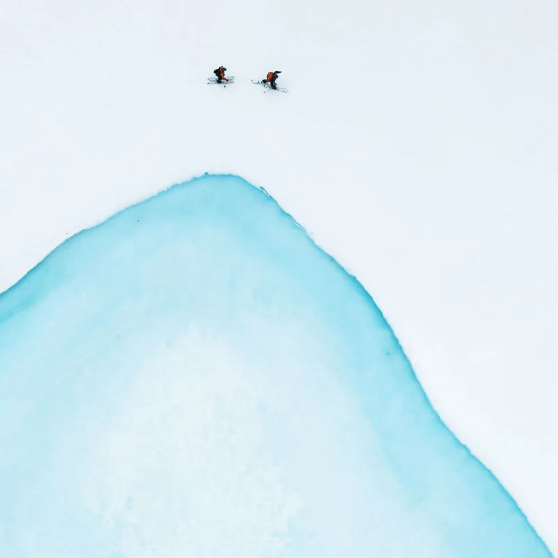 Skiers close to turquoise water