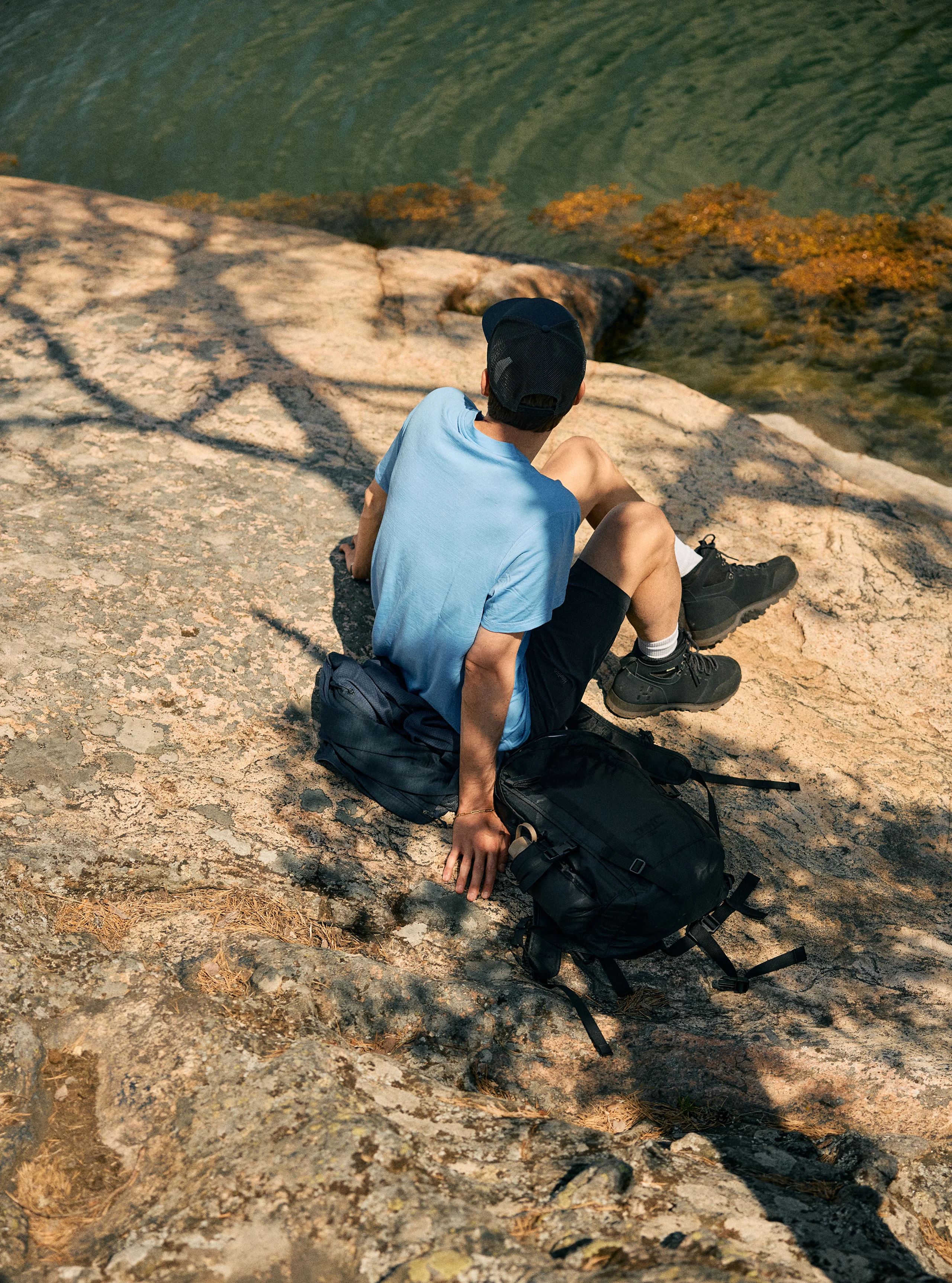 Man in Haglöfs t-shirt sitting close to the sea