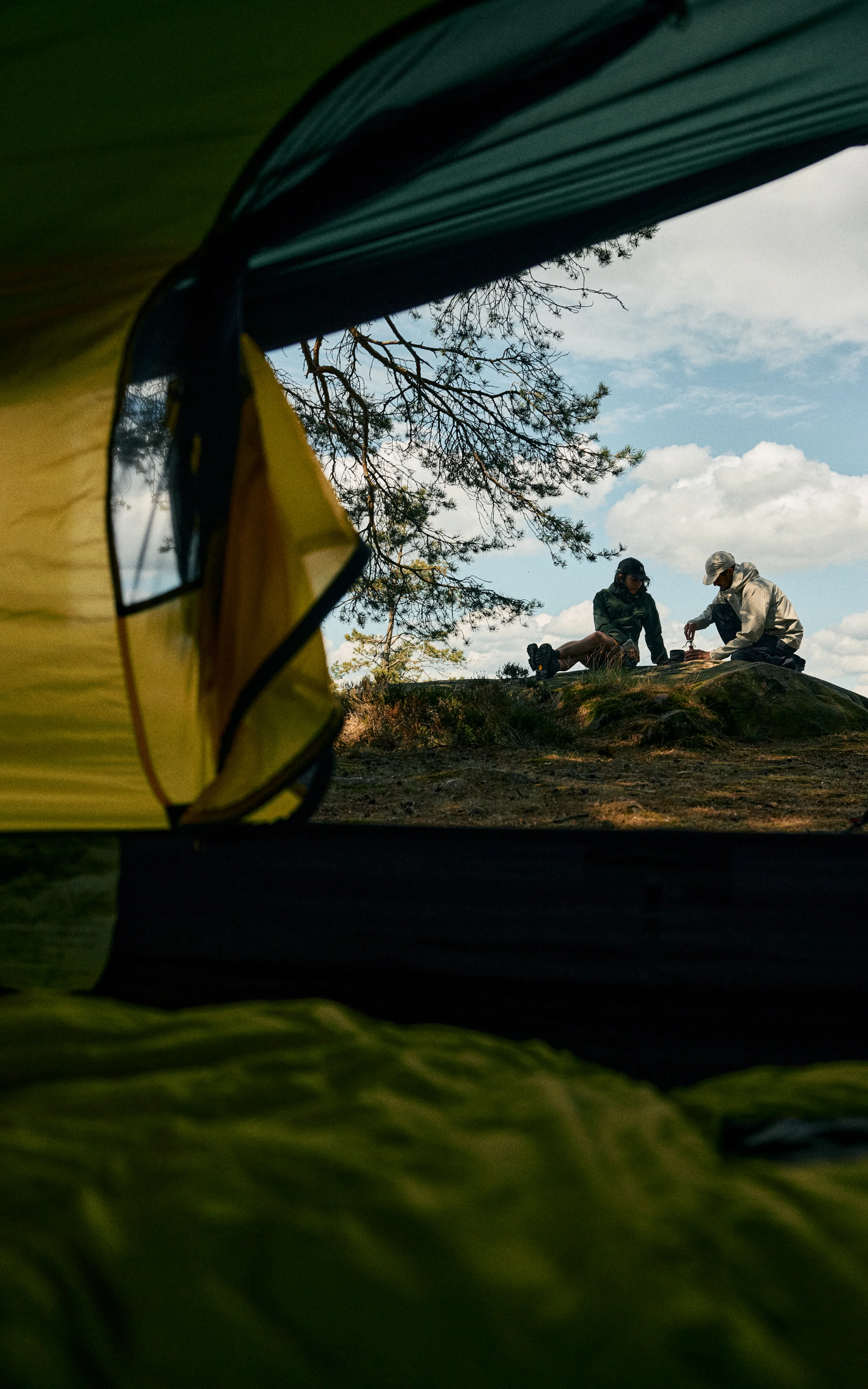 Haglöfs Community Couple sitting outside a tent in Haglöfs clothes outside in nature 