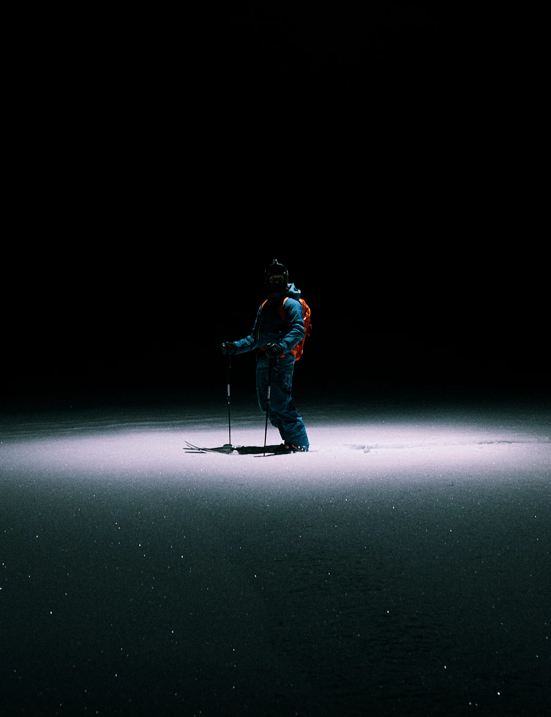 Skier in a dark setting with Vassi ski set on