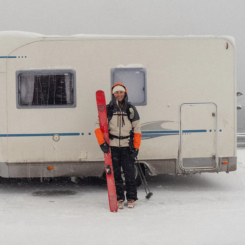 Malva björman outside a camper with skies