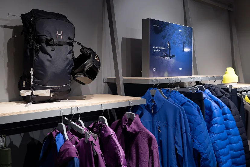 Image of clothes hanging on racks in brand store