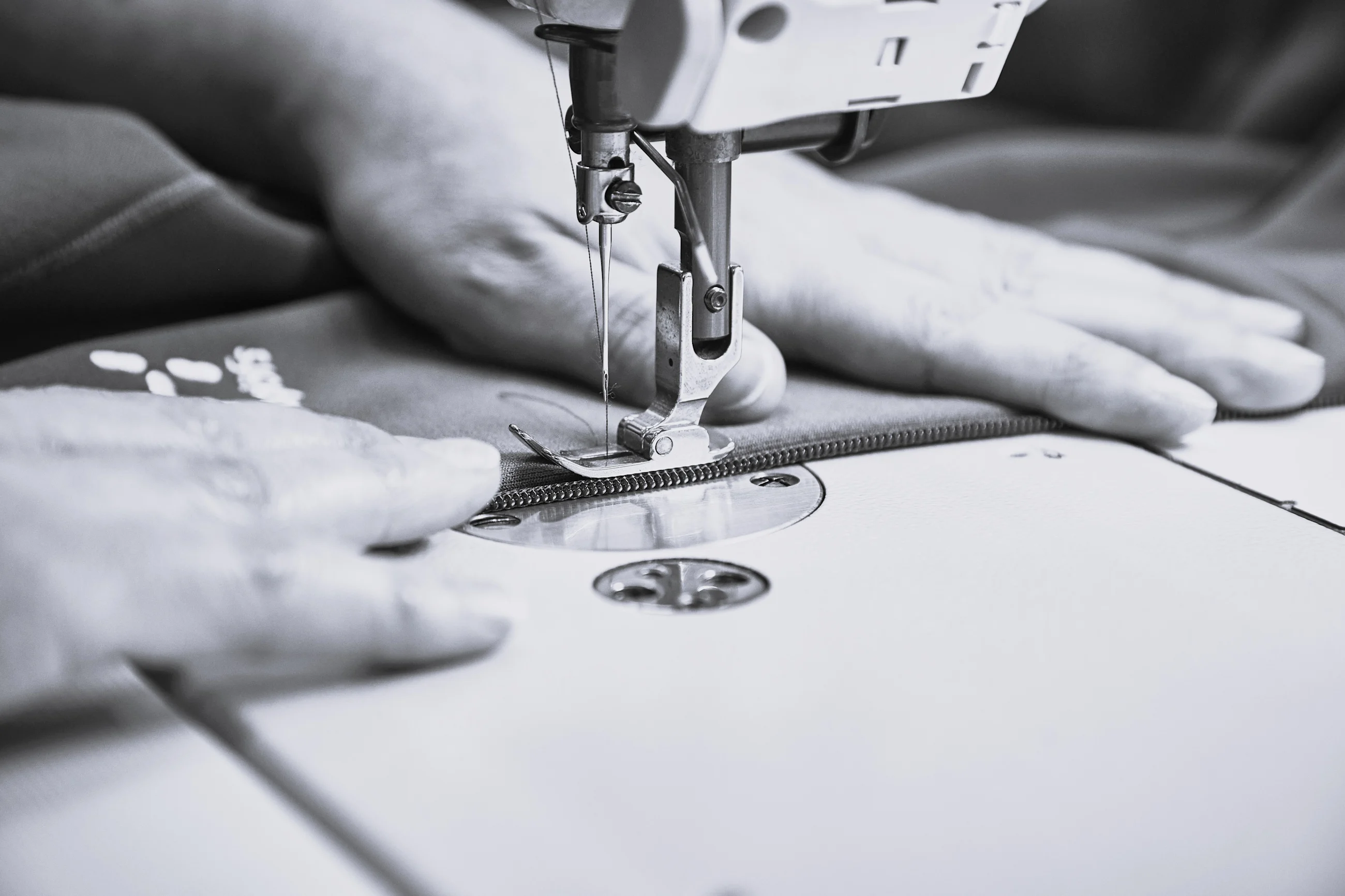 A person sewing on a sewing machine.