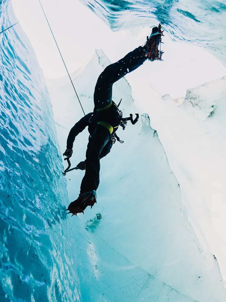 Arthur Poindefert ice climbing a ica covered mountain.